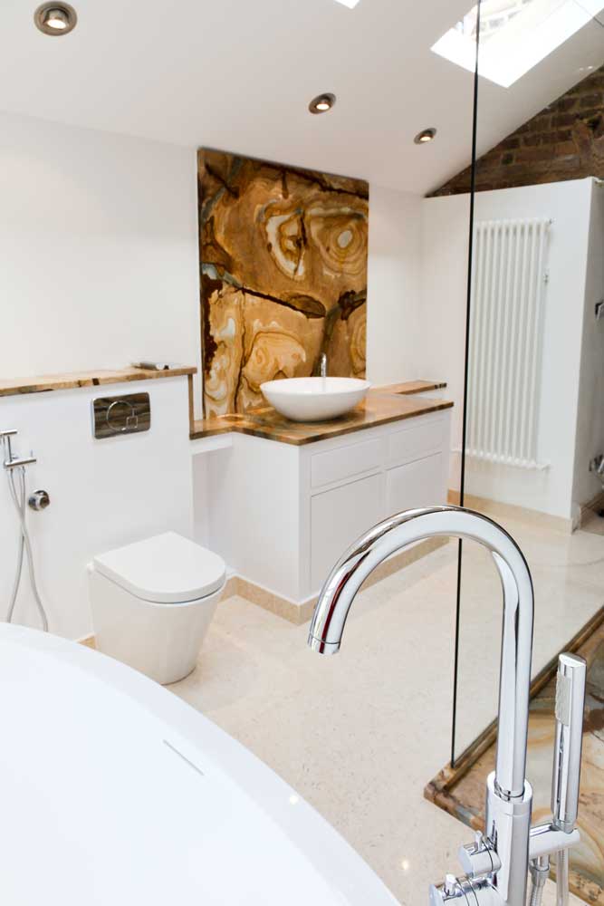 Luxury bathroom renovation with onyx feature wall by KBB Master London